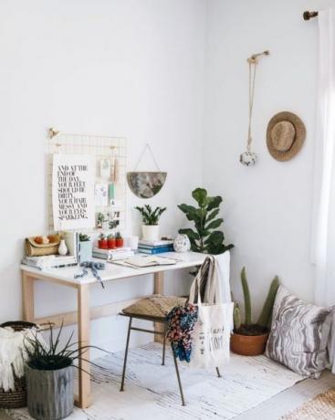 Angolo home office boho chic con piante d'appartamento in macramè da tavolo bianco