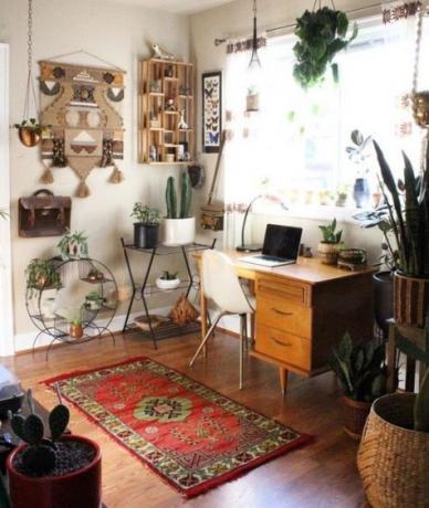 Boho home office, un angolo con un tavolo luminoso, macramè leggermente pretenzioso, piante da interno