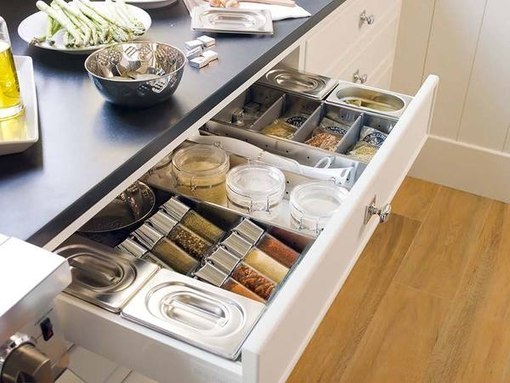 Conservare spezie e contenitori in un cassetto sotto il piano di lavoro
