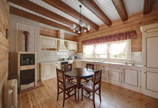 Cucina in stile provenzale con pavimenti in legno e soffitti con travi a vista.